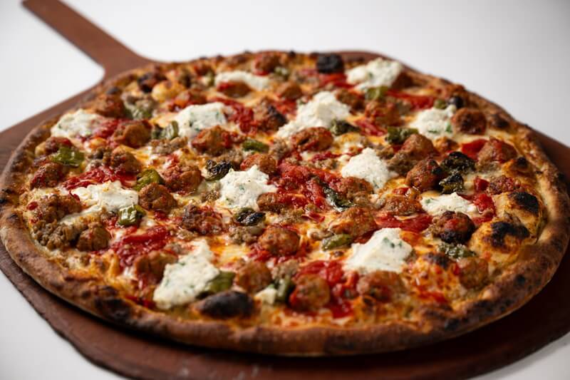 Coal fired pizza with meatballs, sausage, and peppers at Anthony’s, packed with hearty Italian flavor and charred crust.
