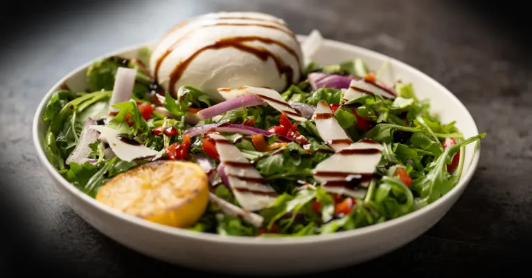 Arugula salad with burrata, parmesan, balsamic glaze, and grilled lemon.