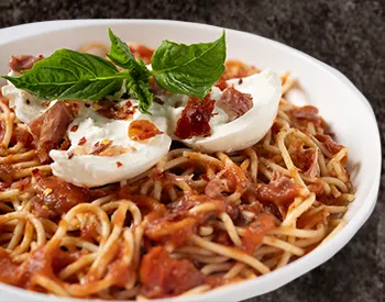 Spaghetti with marinara, burrata, prosciutto, chili flakes, and basil.