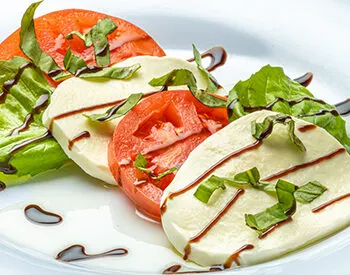 Caprese salad with mozzarella, tomato, basil, and balsamic glaze.