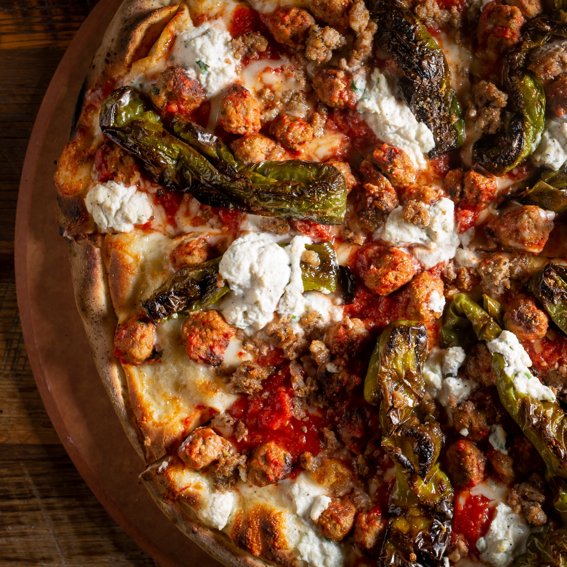 Coal-fired pizza topped with ricotta, sausage, meatballs, and charred peppers.