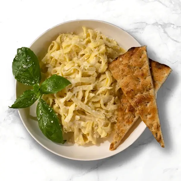 Fettuccine Alfredo with parmesan, basil, and garlic bread.