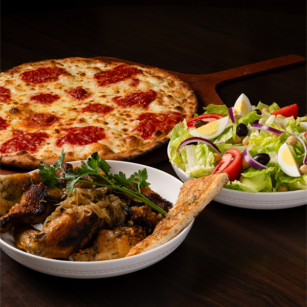 Brick oven pizza with melted cheese and tomato sauce, grilled chicken with caramelized onions, and fresh salad with olives, eggs, and tomatoes.