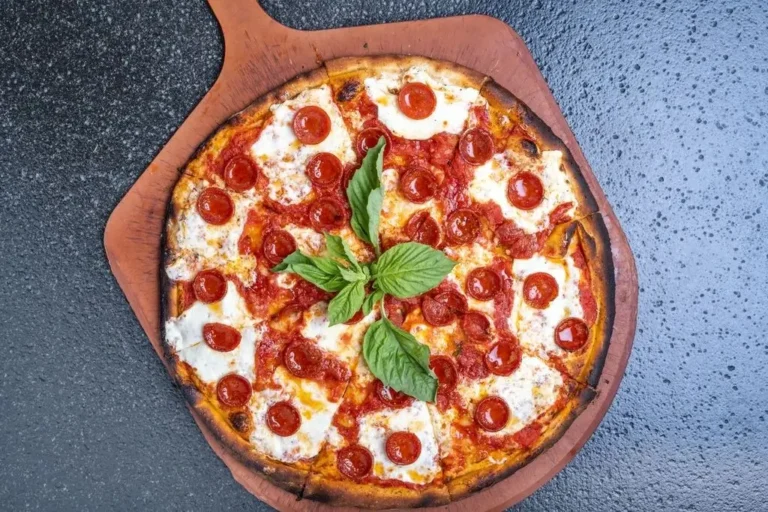 Coal fired pepperoni pizza on a wooden platter, fresh from the oven and ready for pizza delivery from Anthony’s Coal Fired Pizza.