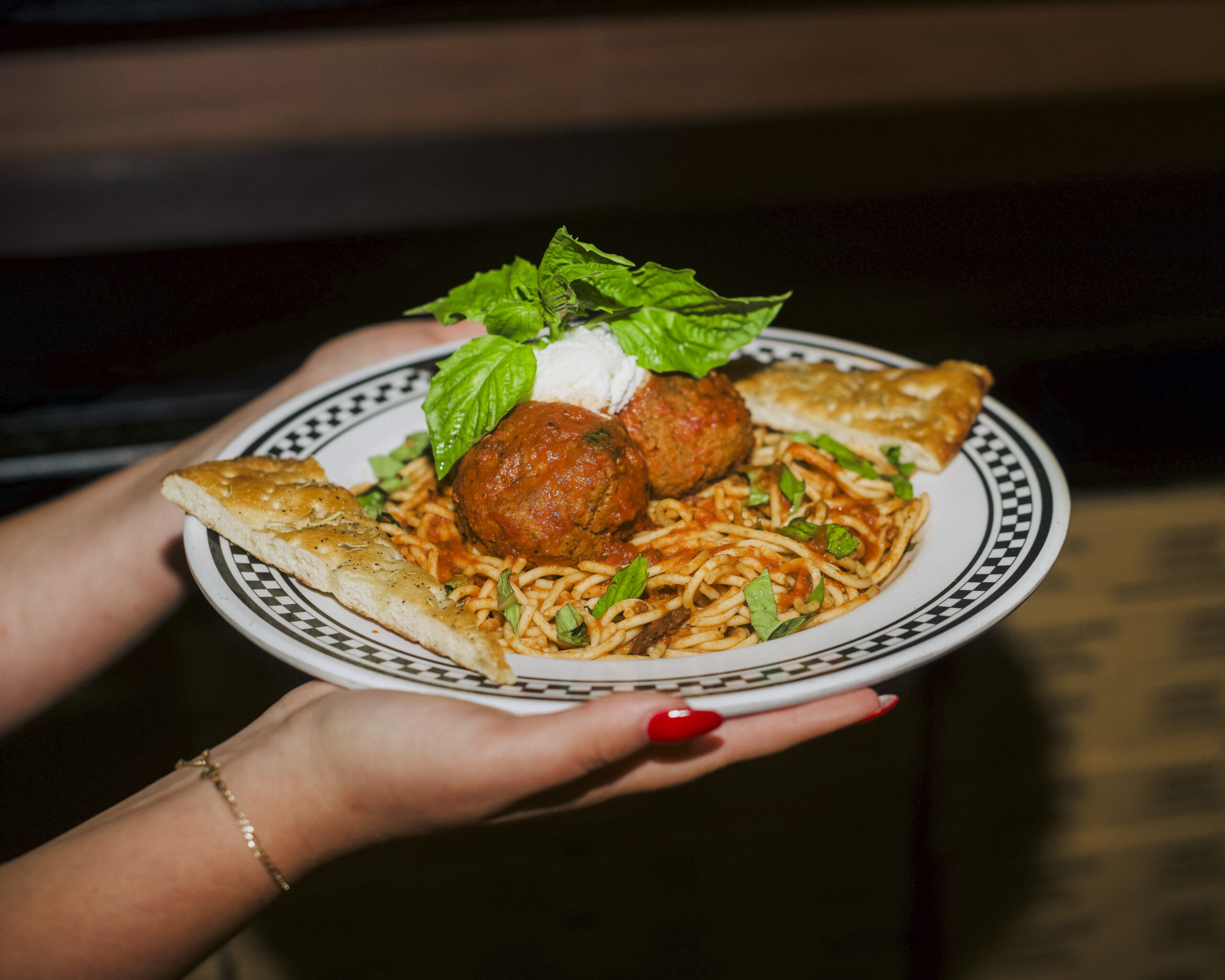 Sphagetti pasta with meatballs in tomato sauce, served with garlic bread.