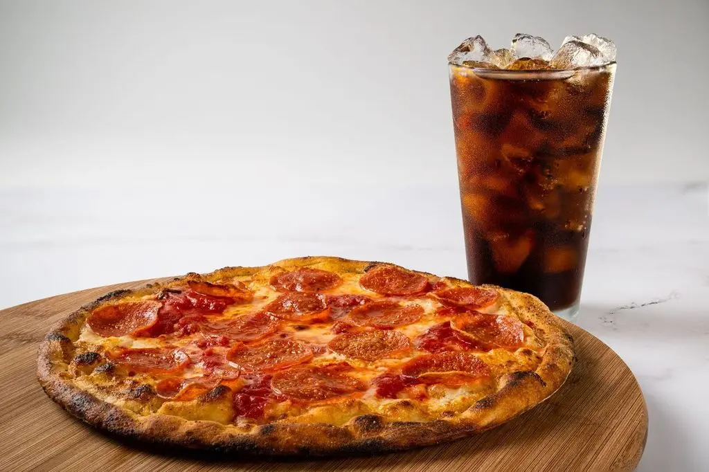 Pepperoni pizza paired with a refreshing Coke, ideal for a hearty meal.
