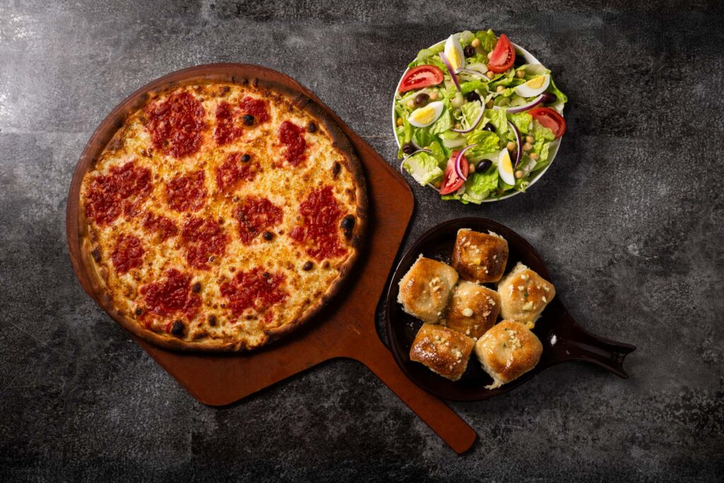 Coal-fired pizza, Caprese salad, and garlic knots served at Anthony’s during Military Appreciation Month.