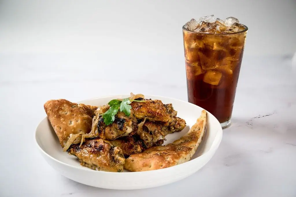 Roasted chicken wings served with bread and a cold Coke, great for a savory snack.