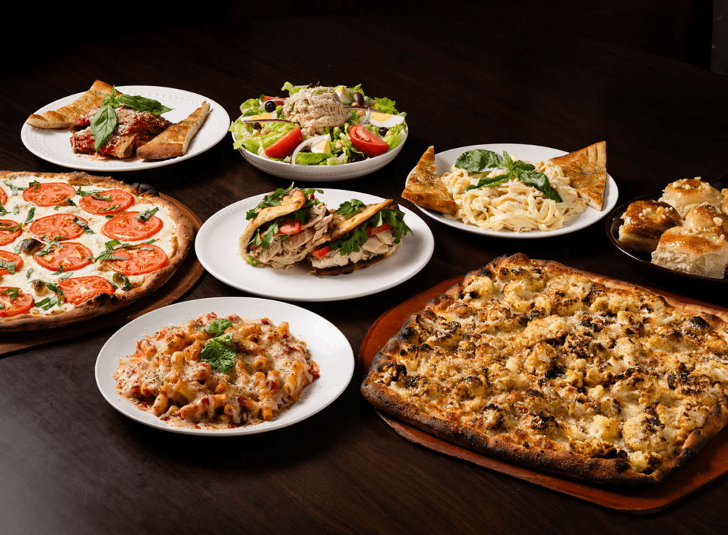 A variety of Italian dishes including pizza, pasta, salad, and garlic bread.