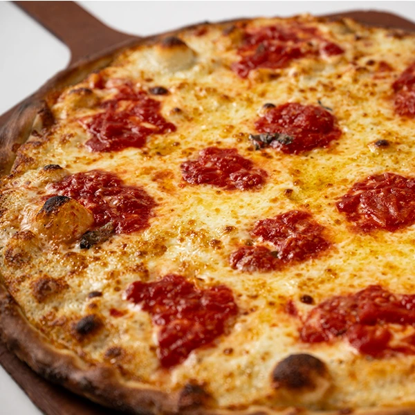 A large cheese pizza sits on a wooden peel, highlighting the Wednesday dine-in special.