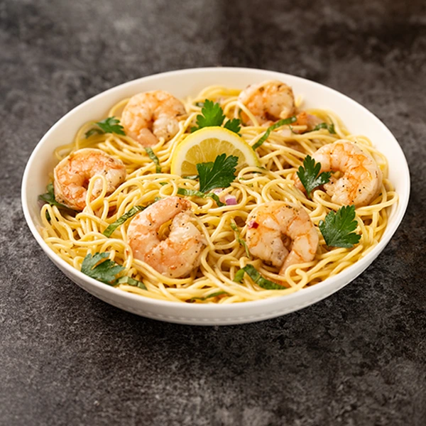 A bowl of shrimp scampi spaghetti with garlic butter shrimp, parsley, and lemon, highlighting the National Shrimp Scampi Day deal.